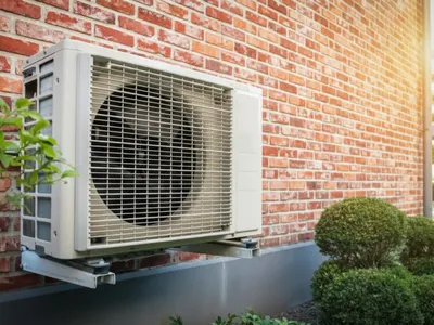 Modern luftvärmepump monterad på villa för energieffektiv uppvärmning och kyla